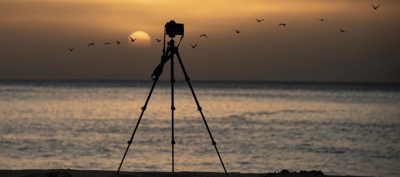 Tripod set up in front of sunset