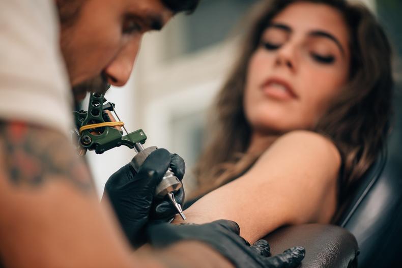 Woman getting tattooed