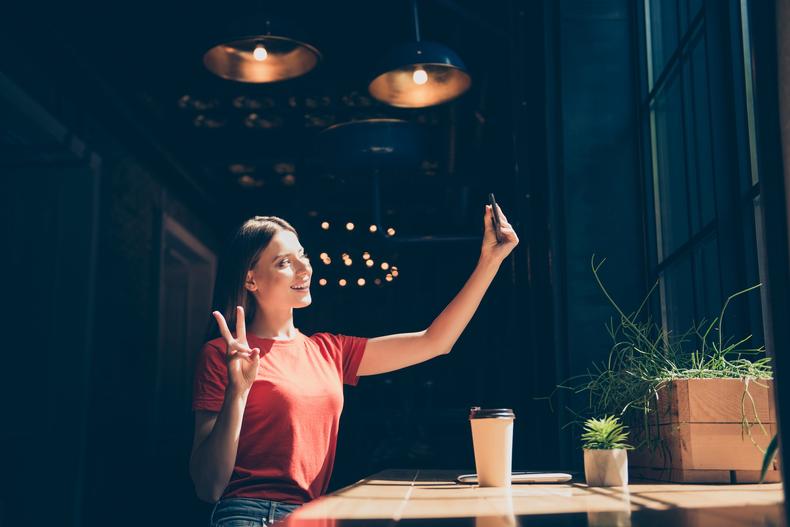 Woman taking a selfie at a cafe