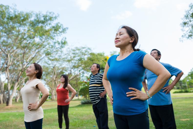 Group of people performing breathing exercises outside