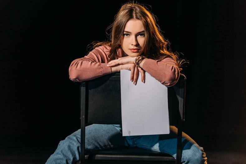 Woman sitting in a chair holding a script