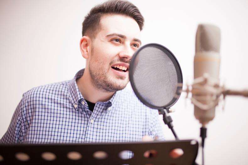 Man recording voiceover in front of a microphone