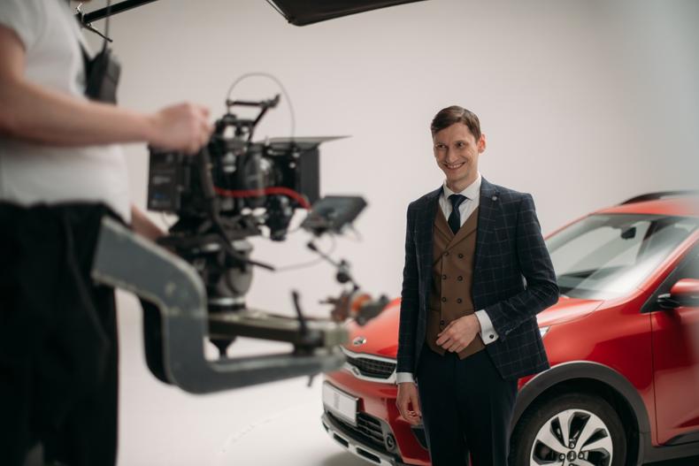 Actor posing in front of a car