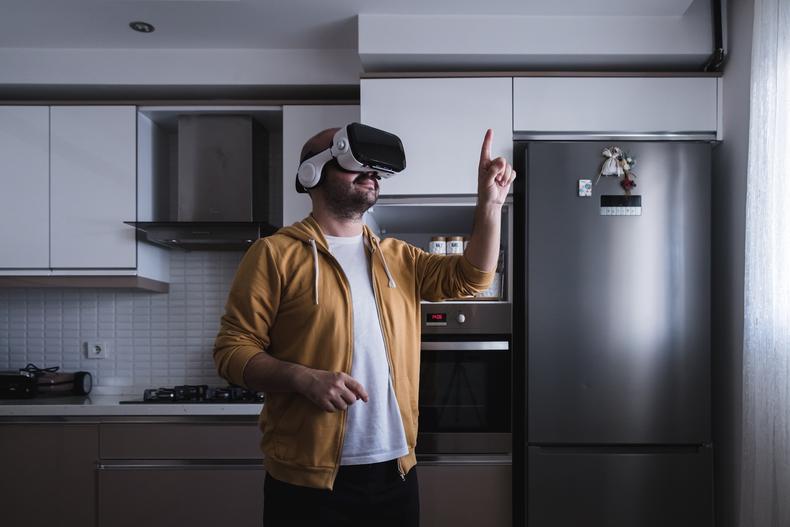 Man using a virtual reality in his kitchen