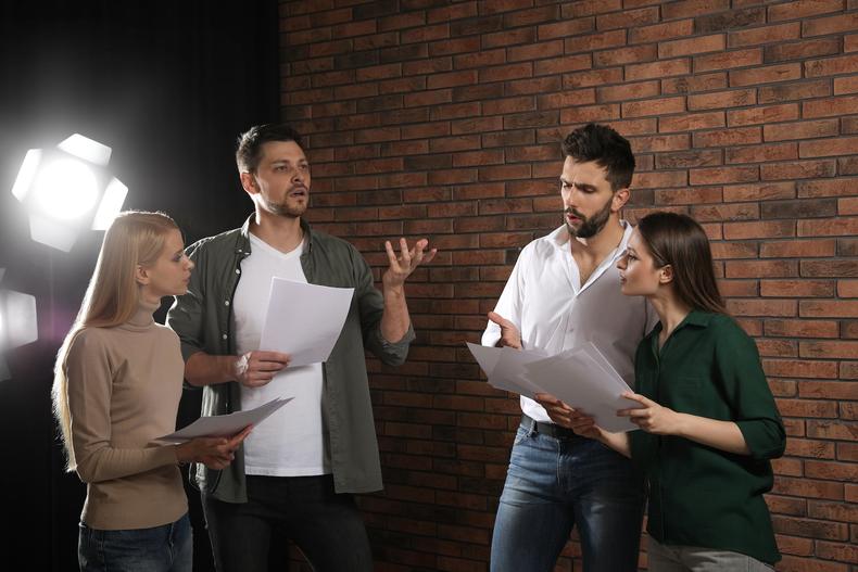 Group of actors reviewing a script