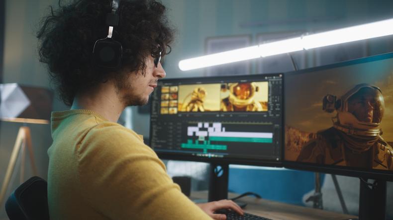 Man editing a movie with a dual-monitor setup