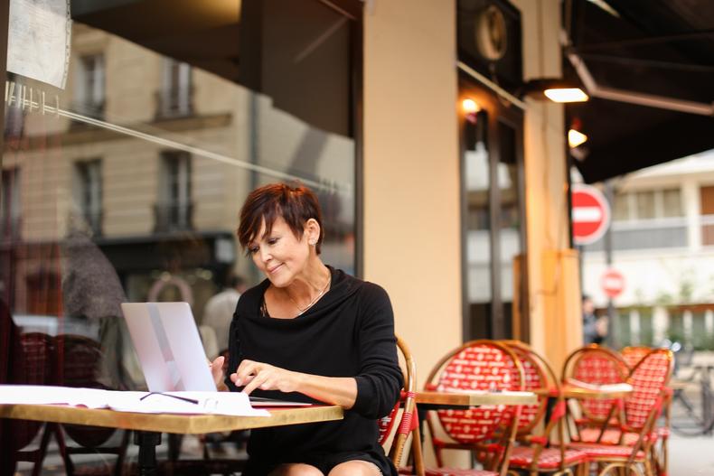 Woman typing at an outdoor cafe