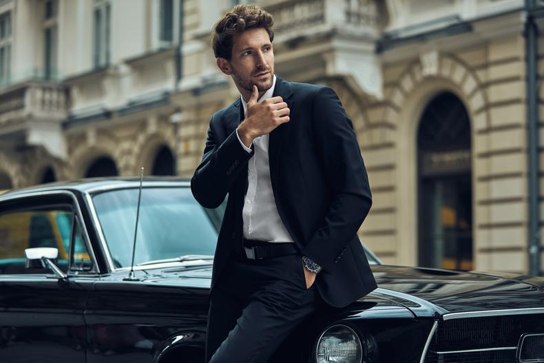 Male model posing by a car