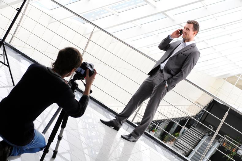 Male model being photographed while holding a cell phone