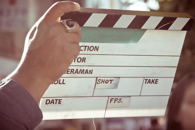 Hand holding a clapperboard
