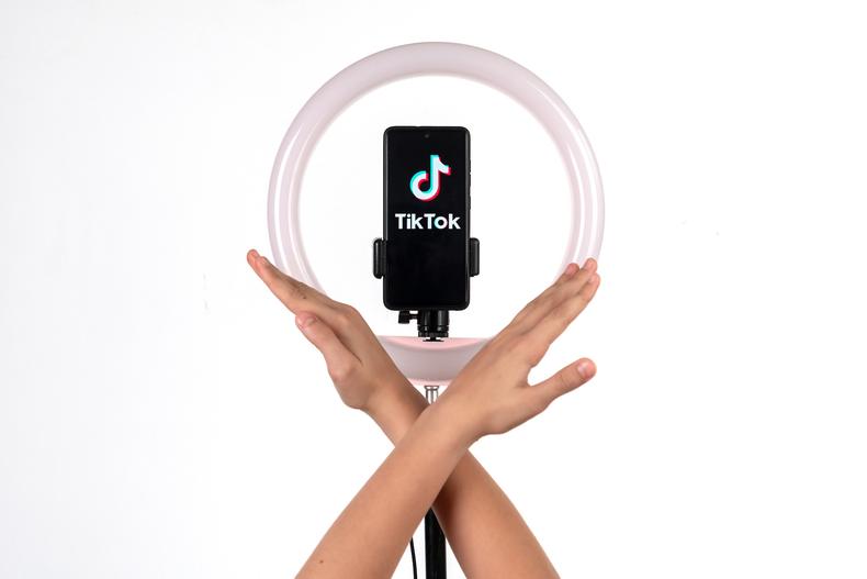 TikTok app on a phone with a ring light setup
