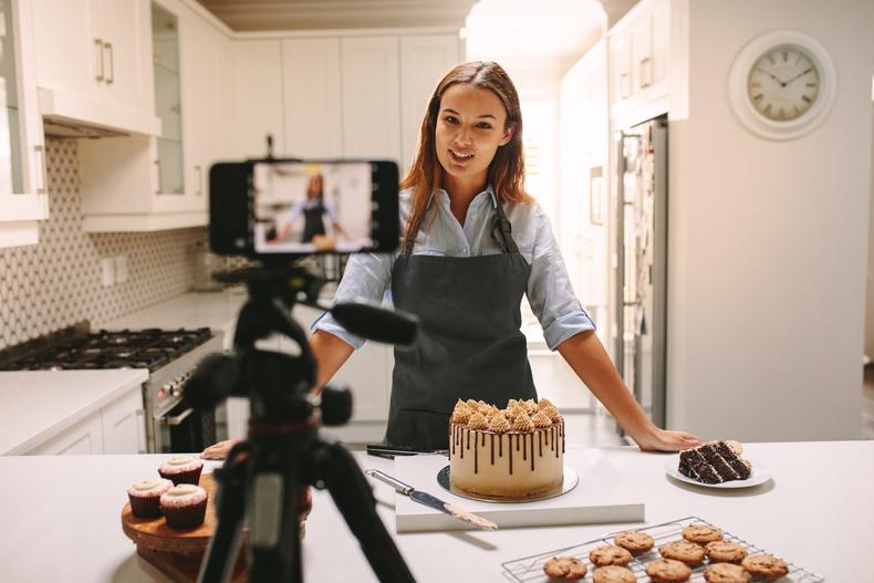 Woman recording a cooking video in her kitchen