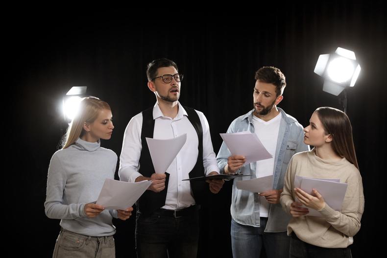 Group of actors reading from scripts