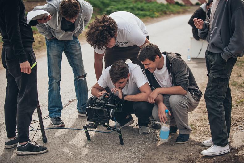 Student filmmakers using a camera