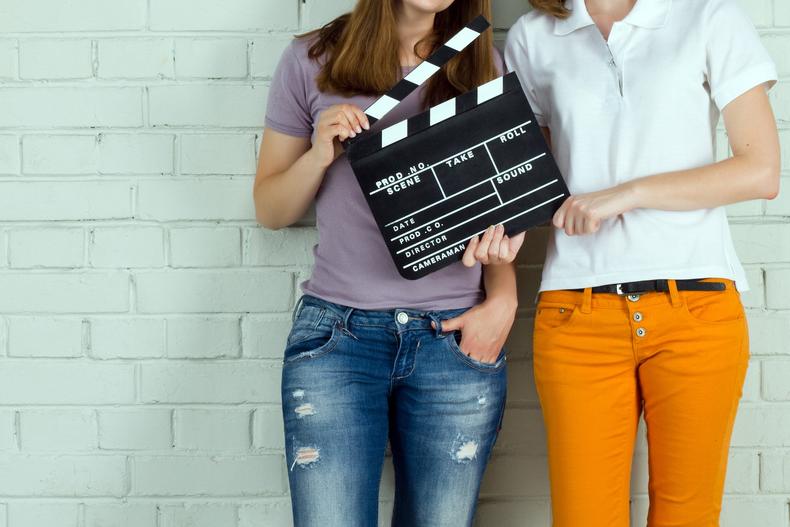 Two women holding a clapperboard