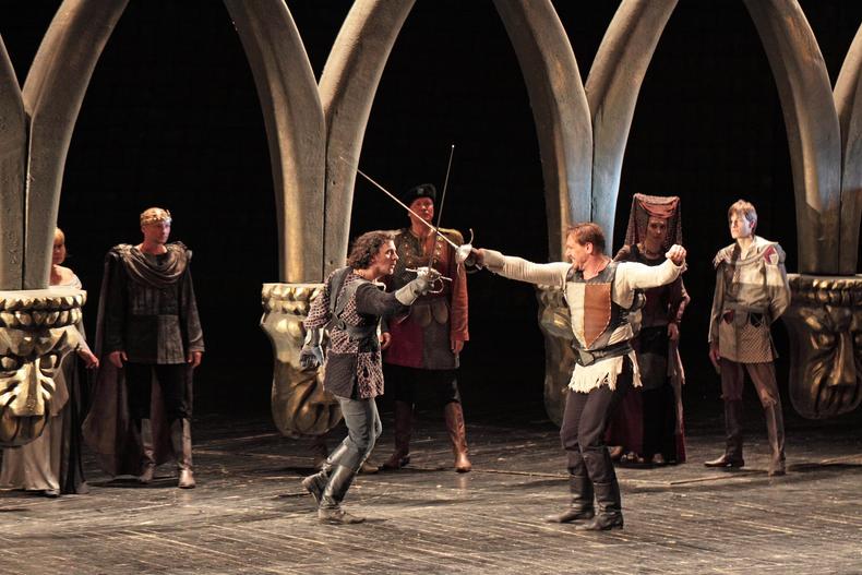 Actors performing a fight scene on stage