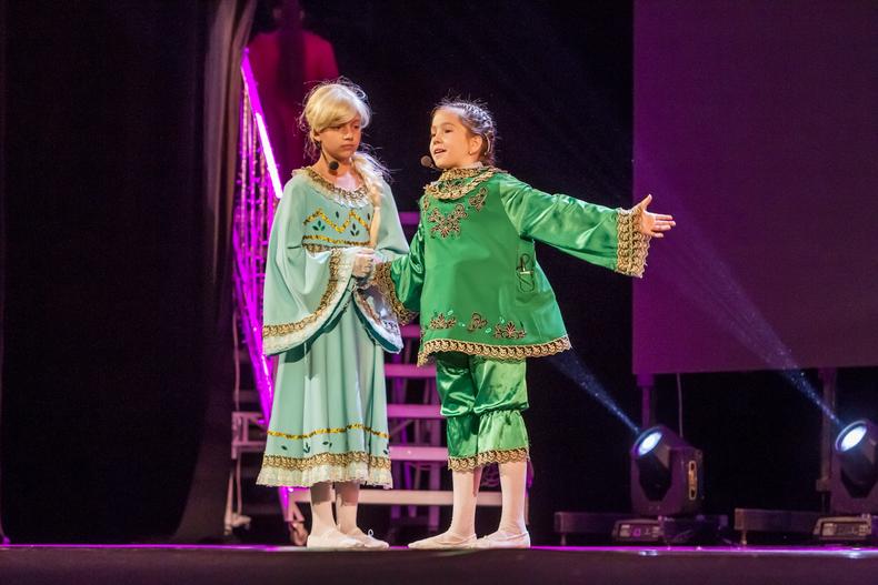 Two female child actors performing on stage