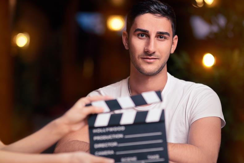 Male actor behind a clapperboard
