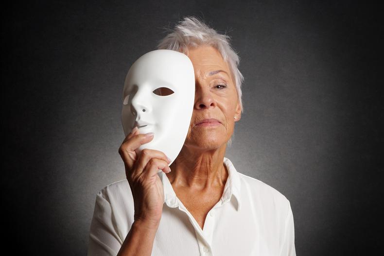 Older actor holding mask