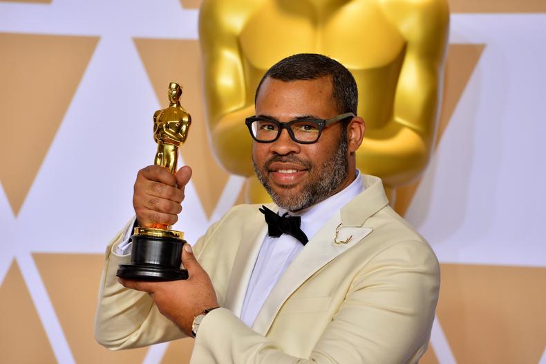 Jordan Peele holding his Oscar
